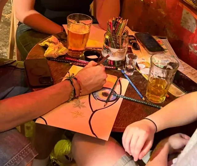 משתתפים מציירים סביב שולחן בבר